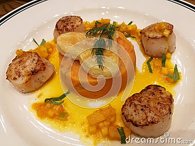 Pan fried seared Hokkaido scallop served with creamy mashed sweet potato and orange sauce top with heart pie. Special dish for cel Stock Photo