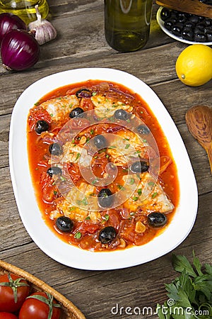 Pan seared fish with tomatoes and olives. Selected focus. Stock Photo