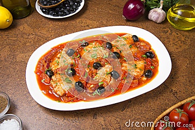 Pan seared fish with tomatoes and olives. Selected focus. Stock Photo