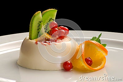 Panacota dessert decorated with orange, kiwi and berries Stock Photo