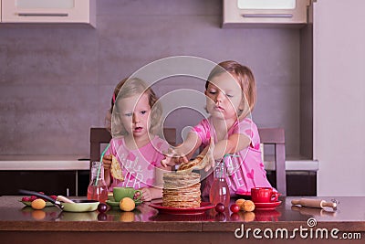Pancake week. Little girls (sisters) eat pancakes. Stock Photo