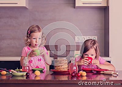 Pancake week. Little girls (sisters) eat pancakes. Stock Photo