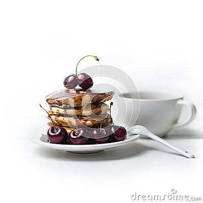 Pancakes with chocolate sauce and fresh cherries on a plate. Combined with coffee. Traditional breakfast Stock Photo