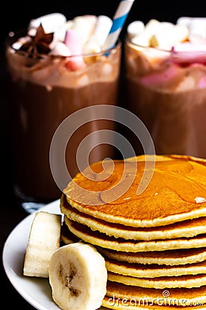 Pancakes, flapjacks, hotcakes, griddlecakes with banana chunks, maple syrup and butter. Christmas breakfast Stock Photo
