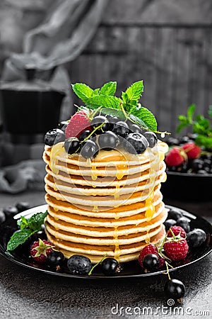 Pancakes with fresh berries. Pancakes with raspberry, blueberry, black currant and honey Stock Photo