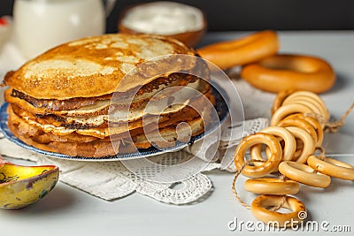 Pancakes on a plate, close-up. A stack of pancakes, on a linen napkin, bagels and a wooden spoon. Selective Focus Stock Photo