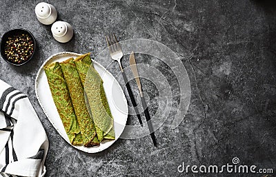 Pancakes with spinach, salmon and cheese on the kitchen table. View from above Stock Photo