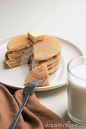 Pancakes stack topping butter and a glass of milk Stock Photo