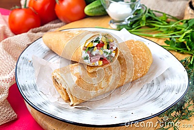 Pancakes stuffed with fresh vegetables and cheese on a plate, breakfast dish Stock Photo