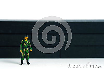 Lockdown illustration â€“ miniature soldier stand guard in front of barrier wall. Cartoon Illustration