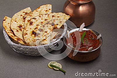 Paneer Butter Masala or Cheese Cottage Curry, popular Indian lunch / dinner menu served with naan or roti on a moody background, Stock Photo