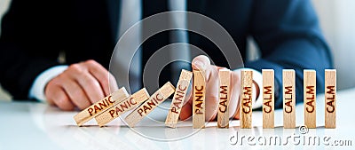 Panic Calm Concept. hand stops falling blocks with the word panic and builds blocks with the word calm. Stock Photo