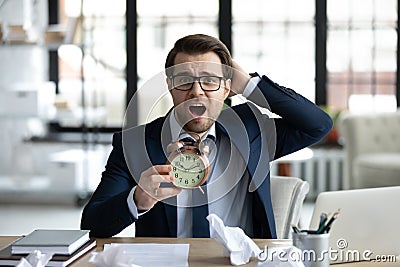 Panic desperate manager missing deadline, holding alarm clock Stock Photo