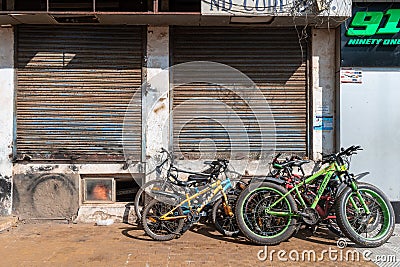 Bicycles parked on a sidewalk outside the closed shops of a market in the city Editorial Stock Photo