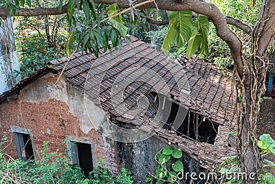 Top angle view of an old rustic dilapidated house with broken tiled roofs Editorial Stock Photo