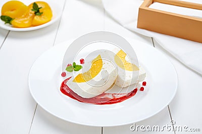 Panna cotta souffle dessert with peach and berry sauce Stock Photo