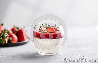 Panna cotta with strawberry and cream in glass with fresh berries on a light background close up with shadow Stock Photo