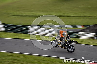 A black and gold racing bike speeding over the brow. Editorial Stock Photo
