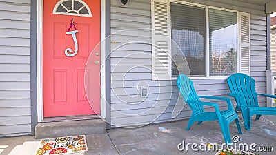 Pano Red front door of house with blue porch chairs against windows with shutters Stock Photo