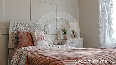 Pano Single bed with decorative headboard and feminine blankets inside a home bedroom Stock Photo