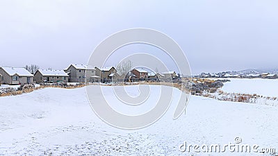 Pano White snowy view of a town with large houses covered in snow Stock Photo