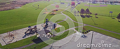 Panorama aerial view empty parking space at community recreational center with playground, huge grassy baseball field and colorful Stock Photo