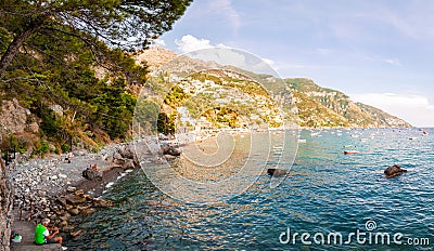 Panorama of amazing Positano cityscape on rocky landscape, people resting, swimming, fishing on the beach, boats are coming and Editorial Stock Photo