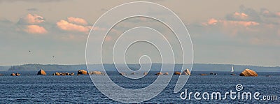 Panorama of Baltic sea shelf with boulders and stones. Clouds, yacht and birds in evening light. Clean nordic nature in gulf Stock Photo