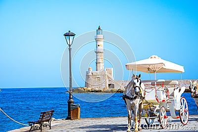 Panorama of the beautiful old harbor of Chania with the amazing lighthouse, mosque, venetian shipyards, at sunset, Crete. Stock Photo