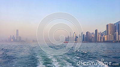 Panorama of the big Asian megalopolis at sunset in a haze, a view of the big city about ship boards, skyscrapers against the backg Stock Photo