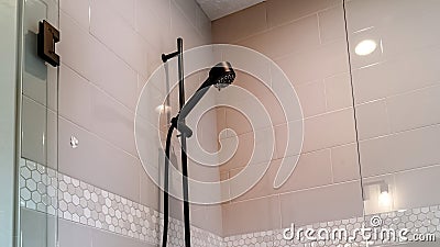 Panorama Black round shower head on tile wall of shower stall with hinged glass door Stock Photo