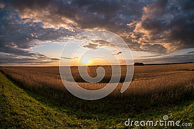 Panorama of blue red sky background with evening fluffy curly rolling clouds with setting sun. Good windy weather Stock Photo