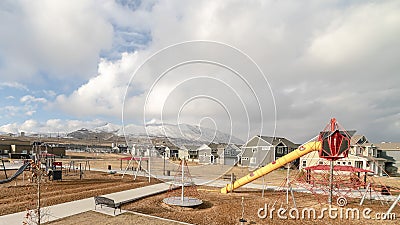 Panorama Childrens playground against snow capped mountain and cloudy sky in winter Stock Photo