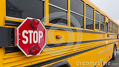 Panorama Exterior view of a yellow school bus with a red stop sign and signal lights Stock Photo