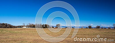 Panorama of field in western colorado with farms and snow capped Stock Photo