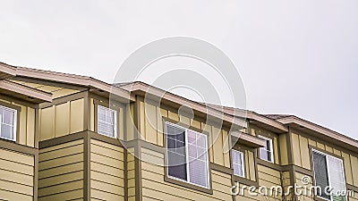 Panorama frame Close up view of exterior of homes with cream wall under sky filled with clouds Stock Photo