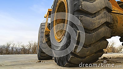 Panorama frame Close up view of the huge black rubber tires of a yellow construction vehicle Editorial Stock Photo