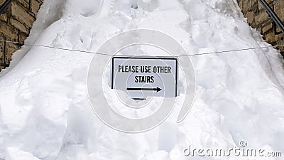Panorama frame Snowed in stairway with sign that reads Please Use Other Stairs in winter Stock Photo