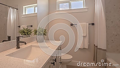 Panorama frame Toilet and vanity with cabinets and sink undermounted on the white countertop Stock Photo