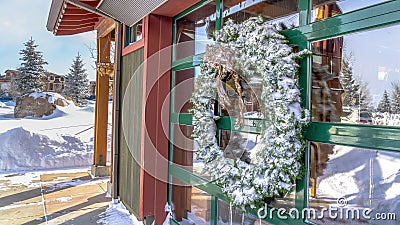 Panorama Frosted wreath on the glass wall of building that reflects the winter landscape Stock Photo