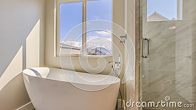 Panorama Glossy bathtub and separate shower inside the sunlit bathroom of a new house Stock Photo