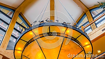 Panorama Gorgeous yellow round light hanging on the ribbed ceiling inside a building Stock Photo