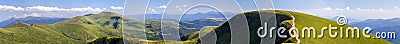 Panorama of green hills in summer mountains with gravel road for Stock Photo