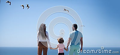 Panorama of happy beautiful family with kids walking together on sea beach during summer vacation. Freedom carefree Stock Photo