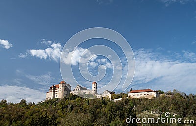 Panorama with Harburg Castle standing on a hill with green trees. The sky is blue with clouds. The castle is built of stones Editorial Stock Photo