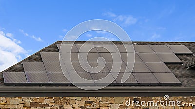 Panorama House with solar panels on the roof against blue sky with clouds Stock Photo