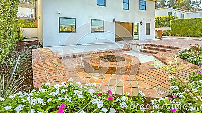 Panorama House with a stone brick patio and octagonal fire pit made of the same material Stock Photo