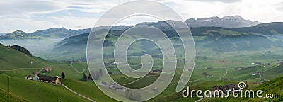 Panorama landscape view of the beautiful Appenzell region in Switzerland with ist rolling hills and farms and the Alpstein mountai Stock Photo