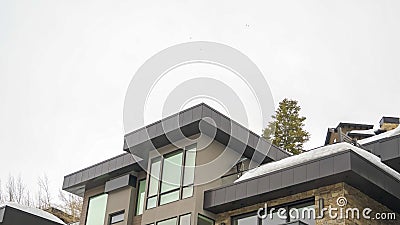Panorama Modern home exterior with stone wall and flat roof against white sky in winter Stock Photo