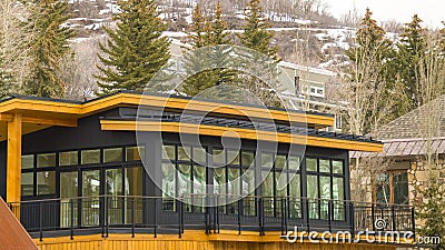 Panorama Modern home exterior with yellow wall balcony flat roof and large windows Stock Photo